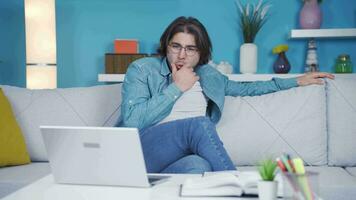 Cheerful young man watching video with funny content.