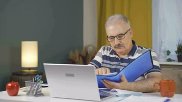 Home office worker man reviewing paperwork files. video