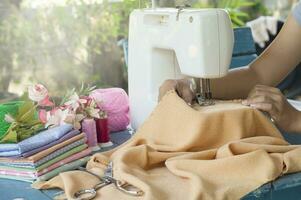 Tailor working on a sewing machine with orange fabric photo