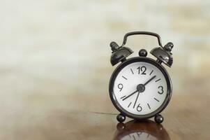 Black alarm clock with bells on the table photo