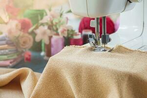 Close up of sewing machine working with orange fabric photo
