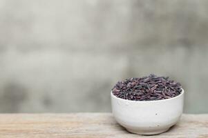 Close up of rice berry in bowl on wooden table photo