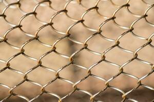 Mesh rabitz , texture of weaving mesh network link. Close up of a fence. barrier on way. metal grid close-up. rusty mesh texture photo