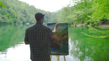 pintor pintura en contra el lago. video