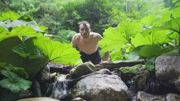 Sportsman doing push-ups at the stream in the forest. video