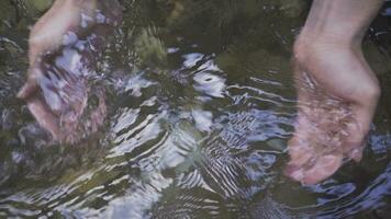 One hand lifts the stream water with the palm of the hand. Slow motion. video