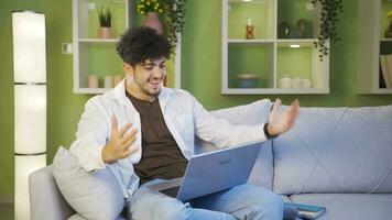 jovem homem alegremente abraçando computador portátil. video