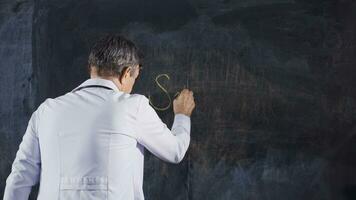 Male doctor writes Surgery on the blackboard. video