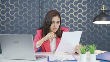 Young business woman examines paperwork and gets upset. video