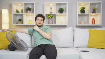 The man using the fan is overwhelmed by the heat. video