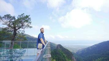 Man looking at nature view from glass terrace. video