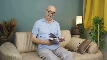 The man looking at the family album is crying. video