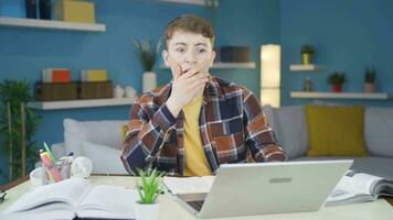 Student watching video on laptop in amazement.