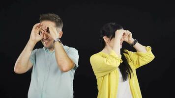 Couple making binoculars with their hands. Search state. video