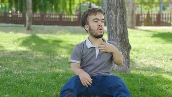 enano joven hombre teniendo falta de aliento al aire libre. video