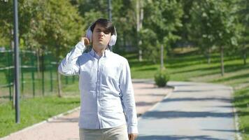 joven hombre escuchando a música al aire libre. video