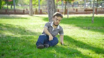 nain Jeune homme avec perte de équilibre, séance dans le parc. video