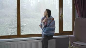 Asian young woman looking out the window at home. video