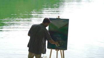 Painter who paints against the lake. Peaceful. video