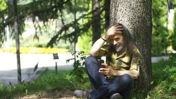 Man in love outdoors, sitting on the ground and happy. video