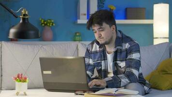 Man looking tired and exhausted at laptop at night. video