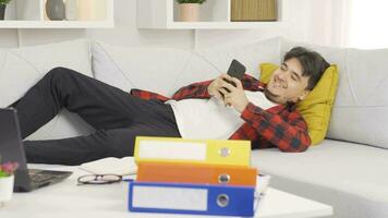 Lazy man laughing at phone in hand and not doing his job. video