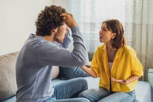 Man and woman are sitting at sofa and arguing. Relationship problems. photo