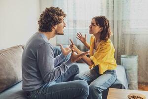 Man and woman are sitting at sofa and arguing. Relationship problems. photo