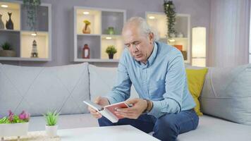 Man looking at family album with trembling hand. video