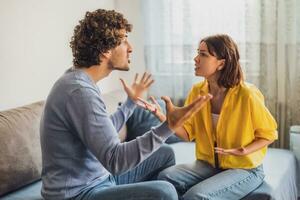 hombre y mujer son sentado a sofá y discutiendo. relación problemas. foto