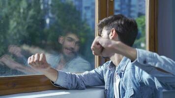 un animado y energético hombre. riendo fuera el ventana con contento expresión. video