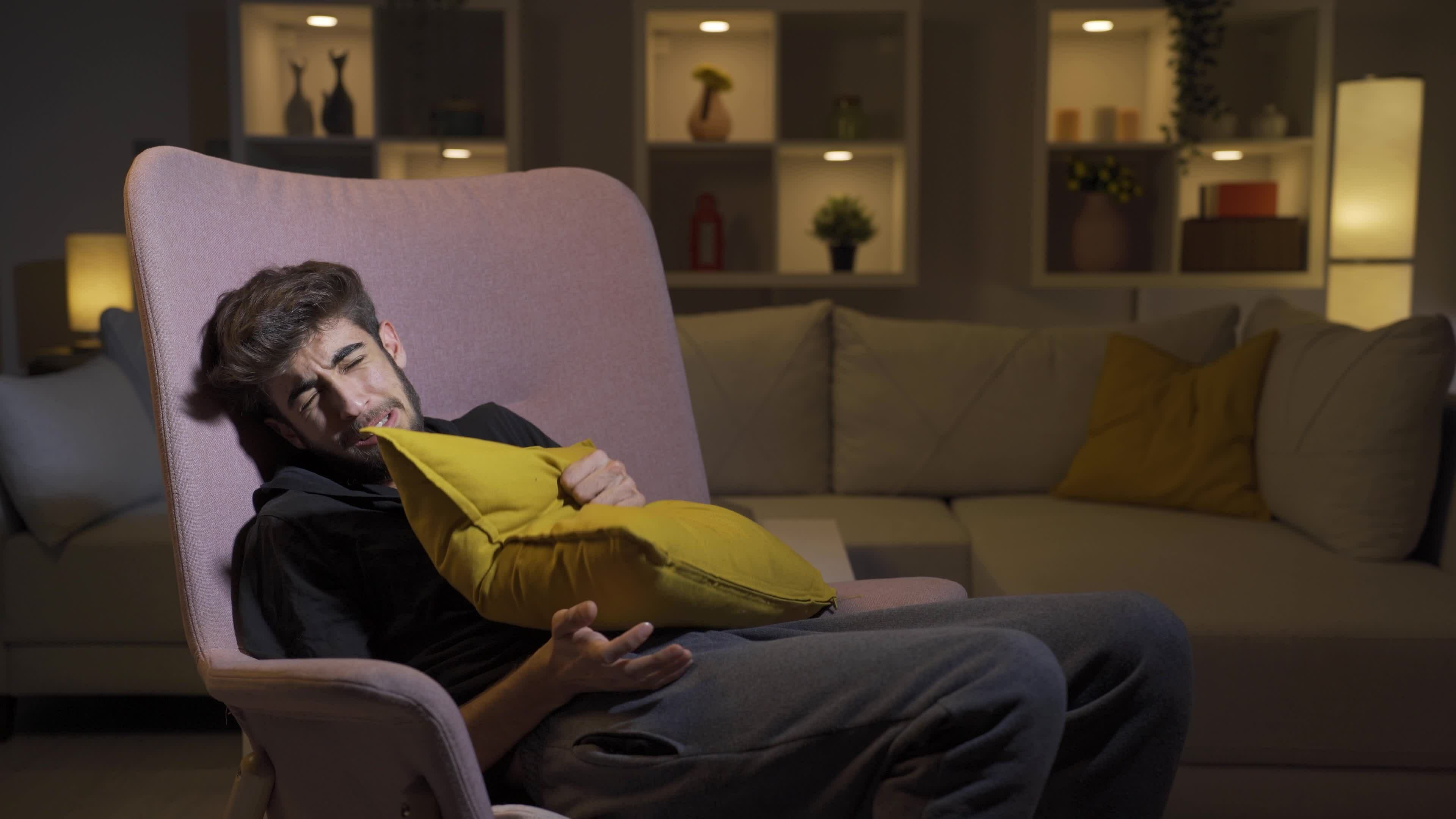 The man who presses the pillows on his head with fear. 33171345 Stock