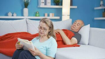 A woman reading a book to her husband. Happy couple. video