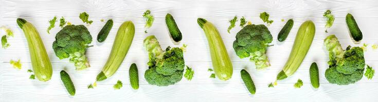 bandera de sano verde vegetales. brócoli, calabacín y pepinos en blanco antecedentes foto