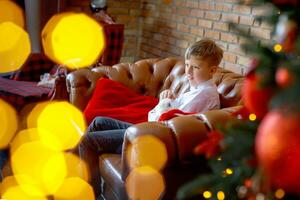 Teenager boy with rabbit in hands on background of new year tree. Child celebrates Christmas. Happy smiling child with pet in arms. photo