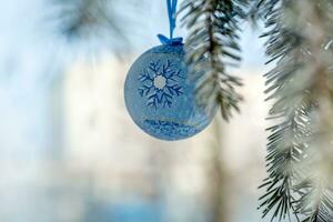 azul pelota Navidad juguete en el de un Navidad árbol rama. Navidad en el ciudad. antecedentes para el nuevo año. foto