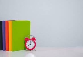 Red alarm and colorful hardcover book, Copy space for text, Back to school, Education concept photo