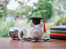 Piggy bank with graduation hat on stack of coins. The concept of saving money for education, student loan, scholarship, tuition fees in future photo