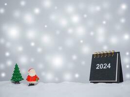 cerca arriba calendario y Navidad decoración con brillante ligero para Navidad y nuevo año Días festivos fondo, invierno estación, que cae nieve, Copiar espacio para Navidad y nuevo año Días festivos saludo tarjeta. foto