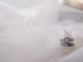 Diamond engagement wedding rings on bridal veil. Wedding accessories, Valentine's day and Wedding day concept. photo