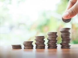 Close up hand putting coin in stack of coins.The concept of save money for prepare in the future. photo