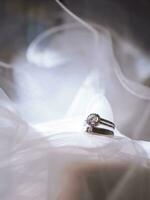 Diamond engagement wedding rings on bridal veil. Wedding accessories, Valentine's day and Wedding day concept. photo