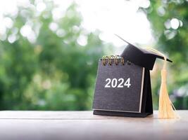 Study goals, 2024 Desk calendar with graduation hat. The concept for Resolution, Goal, Action, Planning, and manage time to success graduate. photo