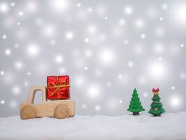 Wooden toy car, Gift box and Christmas tree with shiny light for Christmas and New Year holidays background, Winter season, falling snow, Copy space for Christmas and New Year holidays greeting card. photo