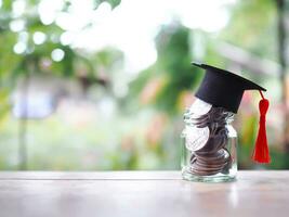 cerca arriba dinero en el vaso botella con graduación sombrero. el concepto de ahorro dinero para educación, estudiante préstamo, beca, matrícula Tarifa en futuro foto