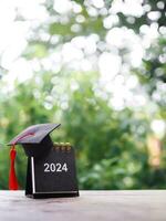 Study goals, 2024 Desk calendar with graduation hat. The concept for Resolution, Goal, Action, Planning, and manage time to success graduate. photo