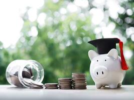 Piggy bank with graduation hat, Glass bottle and stack of coins. The concept of saving money for education, student loan, scholarship, tuition fees in future photo