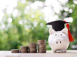 Piggy bank with graduation hat, Glass bottle and stack of coins. The concept of saving money for education, student loan, scholarship, tuition fees in future photo