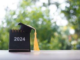 Study goals, 2024 Desk calendar with graduation hat. The concept for Resolution, Goal, Action, Planning, and manage time to success graduate. photo