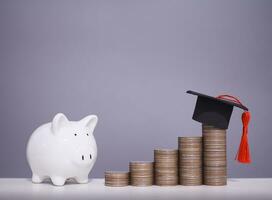 Piggy bank and stack of coins with graduation hat, The concept of saving money for education, student loan, scholarship, tuition fees in future photo